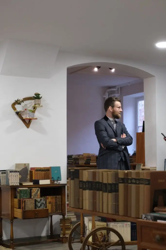 Der Buchhüter zwischen den Bücherregalen seines Antiquariats