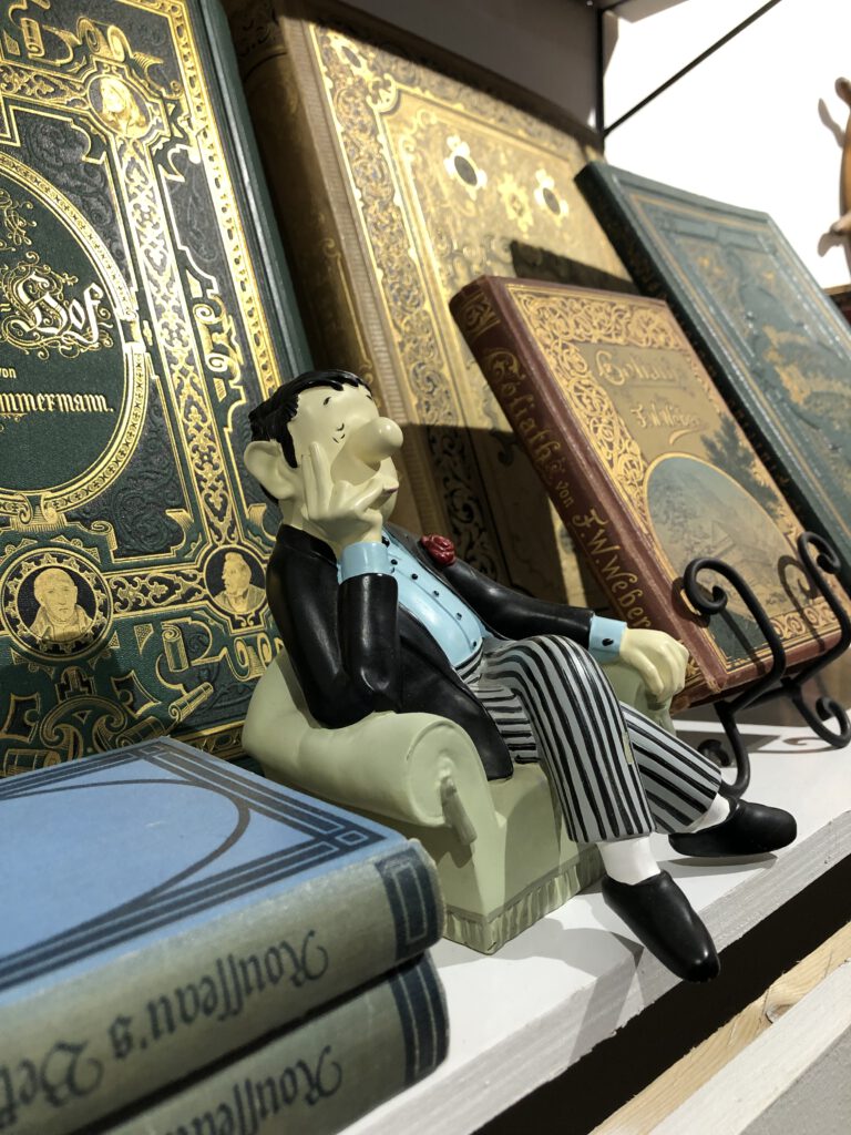 Loriot-Buchstützen und alte Bücher